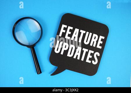 Feature Updates text with magnifying glass on blue background Stock Photo
