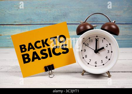 Back To Basics text written on paper card with alarm clock on wooden background Stock Photo