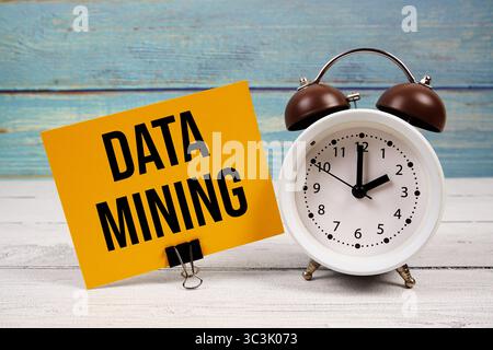 Data Mining text written on paper card with alarm clock on wooden background Stock Photo