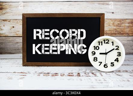 Record Keeping text message and alarm clock on wooden background Stock Photo