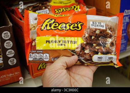 Los Angeles, California, United States - 02-12-2020: A hand holds a package of Reese's peanut butter chips on display at a local grocery store. Stock Photo