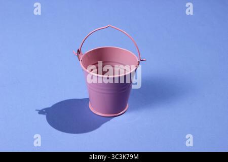 Empty mini pink bucket on purple background. Studio shot with shadow Stock Photo