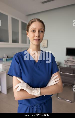 Confident female doctor in blue scrubs posing for profile picture Stock Photo