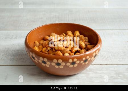 A view of roasted peanuts in a clay bowl. Stock Photo