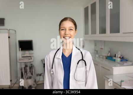 Happy ultrasound diagnosing doctor posing in her office in clinic Stock Photo