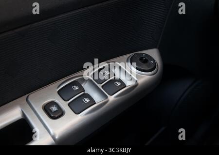 Close-up of the side door buttons: window adjustment buttons, door lock. Window control panel in a modern car. Automatic car window controls and detai Stock Photo