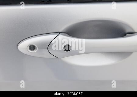 car door handle with rubber keyless entry button to open the vehicle without looking for the key in the pockets wasting no time Stock Photo