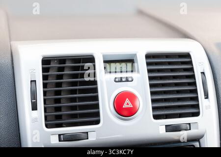 Close-up on emergency button in red color with clock near the duct in the interior of an old Japanese car in gray after dry cleaning Stock Photo
