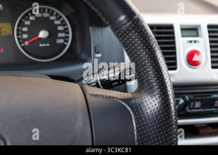 Wiper mode selection button with automatic adjustment through the rain sensor on the steering column of the car. The choice of weather. Stock Photo