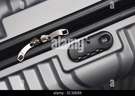 Suitcase zipper with lock. Close up of travel luggage security system. Grey textured surface with metallic details. Modern travel accessory. Stock Photo