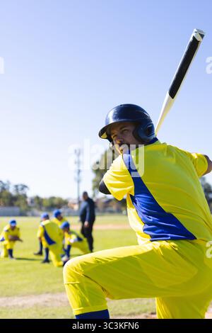 Mature male baseball batter holding bat over shoulder at suburban baseball field, copy space Stock Photo