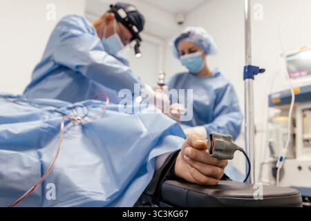Two medical professionals in blue surgical attire are engaged in a surgical procedure, emphasizing collaboration and the importance of precision in he Stock Photo