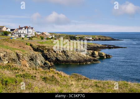 Coast of Anglesey on the outskirts of Porthllechog, or Bull Bay, and The Trecastell Hotel, on a sunny spring morning with blue sky, deep blue sea... Stock Photo