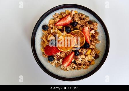 A Deliciously Healthy Breakfast Bowl Filled with Granola, Fresh Fruits, and Nuts for a Nutritious Start to Your Day Stock Photo