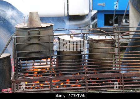 Large Food Cooking Pots on an Open Air Coal Fire. Stock Photo