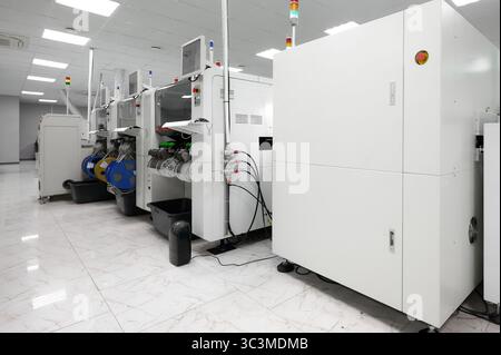 High-precision tape feeders in an SMT pick-and-place machine setup in a modern electronics manufacturing facility Stock Photo