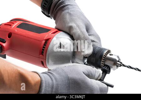 Closeup of worker hands holding electric drill on white background Stock Photo