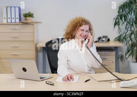 Office worker talking on the phone and smiling Stock Photo