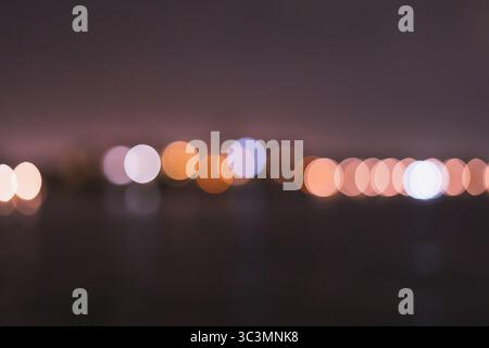 A captivating display of blurred city lights in soft focus, forming an abstract pattern against a dark background. The ethereal glow creates a magical Stock Photo