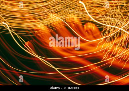 Stunning long exposure of Halloween lighting creates a mysterious, swirling tapestry of vibrant orange and yellow streaks against a dark backdrop, evo Stock Photo