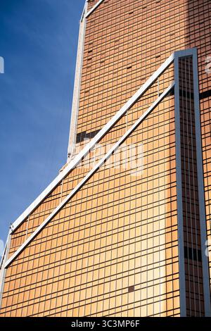 A striking example of modern architecture, showcasing geometric patterns and sleek lines. The building features a dynamic facade that captures sunligh Stock Photo