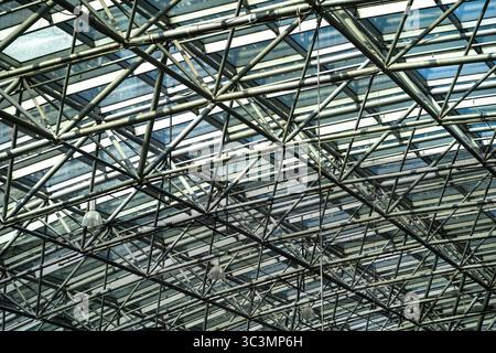 A captivating view of a modern architectural roof, showcasing intricate steel beams and glass panels. This structure exemplifies contemporary construc Stock Photo