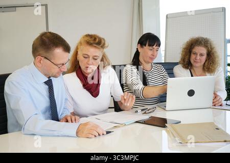 4 office workers working in the meeting room Stock Photo