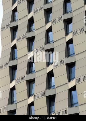Modern city architecture featuring a striking geometric facade with repeating patterns. The structure displays innovative design and contemporary urba Stock Photo