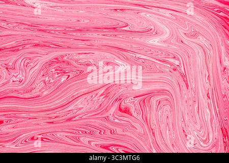 Vibrant pink acrylic paint background with intricate swirling patterns creates a dynamic visual texture. Perfect for design projects needing bold colo Stock Photo