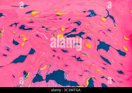 Dynamic acrylic paint background showcasing vibrant swirls of pink, yellow, and blue, creating an abstract and vivid visual experience. Perfect for ar Stock Photo