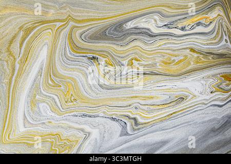 Abstract background featuring swirling patterns of acrylic paint in vibrant yellow and gray tones. This dynamic design provides a fluid, artistic text Stock Photo