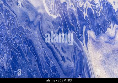 Beautiful abstract acrylic paint background featuring fluid, swirling patterns in captivating blue tones. The intricate design creates a visually stun Stock Photo