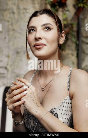 A close-up portrait of a modern glamorous young woman with a stylish braid hairstyle, exuding confidence and elegance as she gazes thoughtfully away f Stock Photo