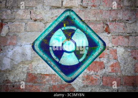 Bright radioactive sign on old brick wall. Radiological pollution Stock Photo