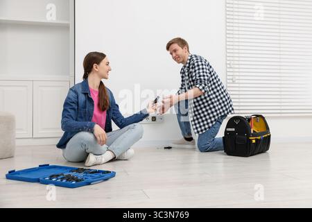 Couple with tools installing new socket at home Stock Photo