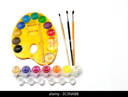 A new school year is about to start, it's time for parents to get their school supplies. Isolated photo of a watercolor set with brushes on a white ba Stock Photo