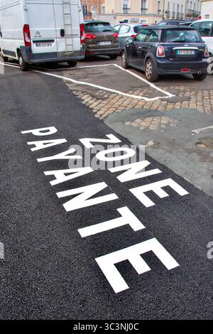 Painted "Zone Payante" on new road surface next to car parking area with poor road surface - Tours, Indre-et-Loire (37), France. Stock Photo