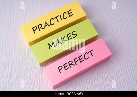 Colorful sticky notes with text practice makes perfect on white background Stock Photo
