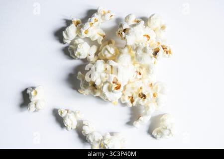 Freshly popped popcorn scattered across a with background Stock Photo