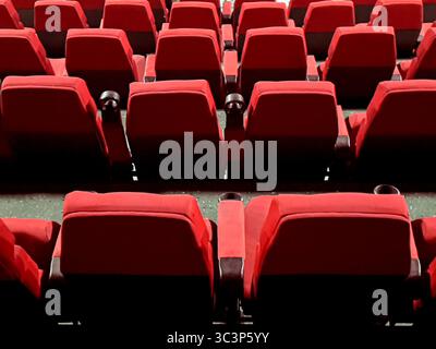 Rows of empty red cinema seats in an empty movie theater waiting for audience Stock Photo