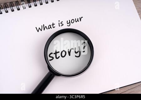 What is your story? text on notepad and magnifying glass Stock Photo