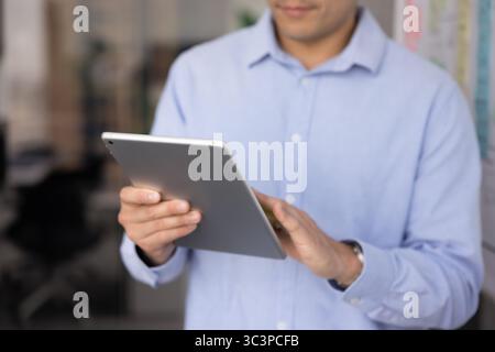 Close up businessman working on digital tablet Stock Photo
