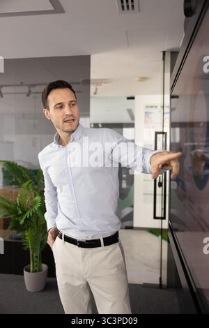 Man presenting infographic data displayed on monitor Stock Photo