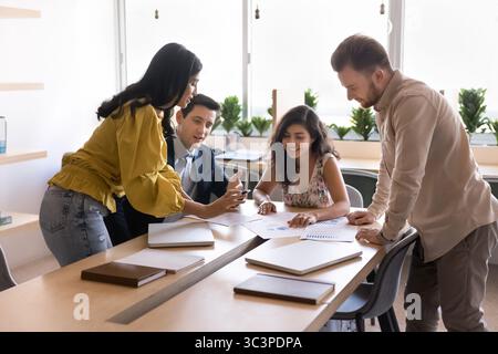Group of four multiethnic workmates engaged in brainstorming session Stock Photo