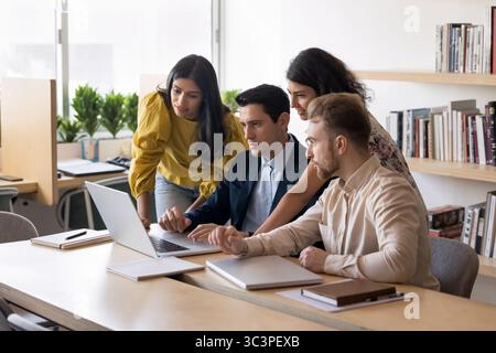 Focused teammates using laptop in modern office Stock Photo