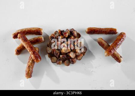 A top down view of a whole sausage links and sliced sausage links, against a white background. Stock Photo