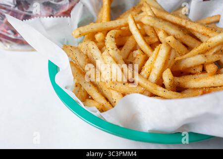 A closeup view of a basket of seasoned french fries. Stock Photo