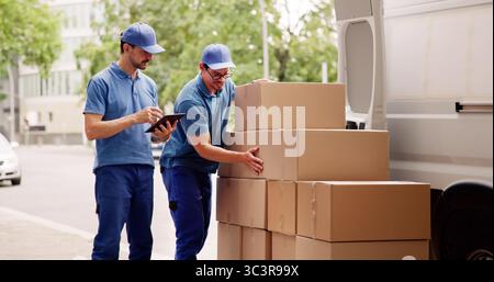 The Professional Mover Unloading Boxes From The Delivery Truck. Stock Photo