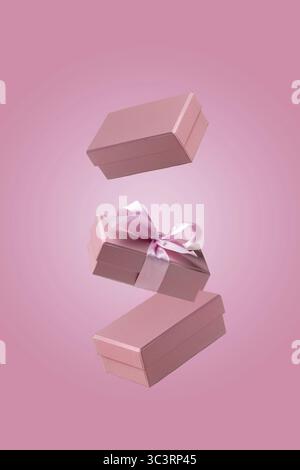 Three craft gift boxes fly on pink background Stock Photo