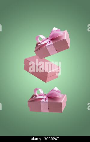 Pink gift boxes fly on a green background Stock Photo